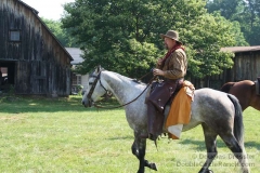 Cowboy on Horse Near Old Barn